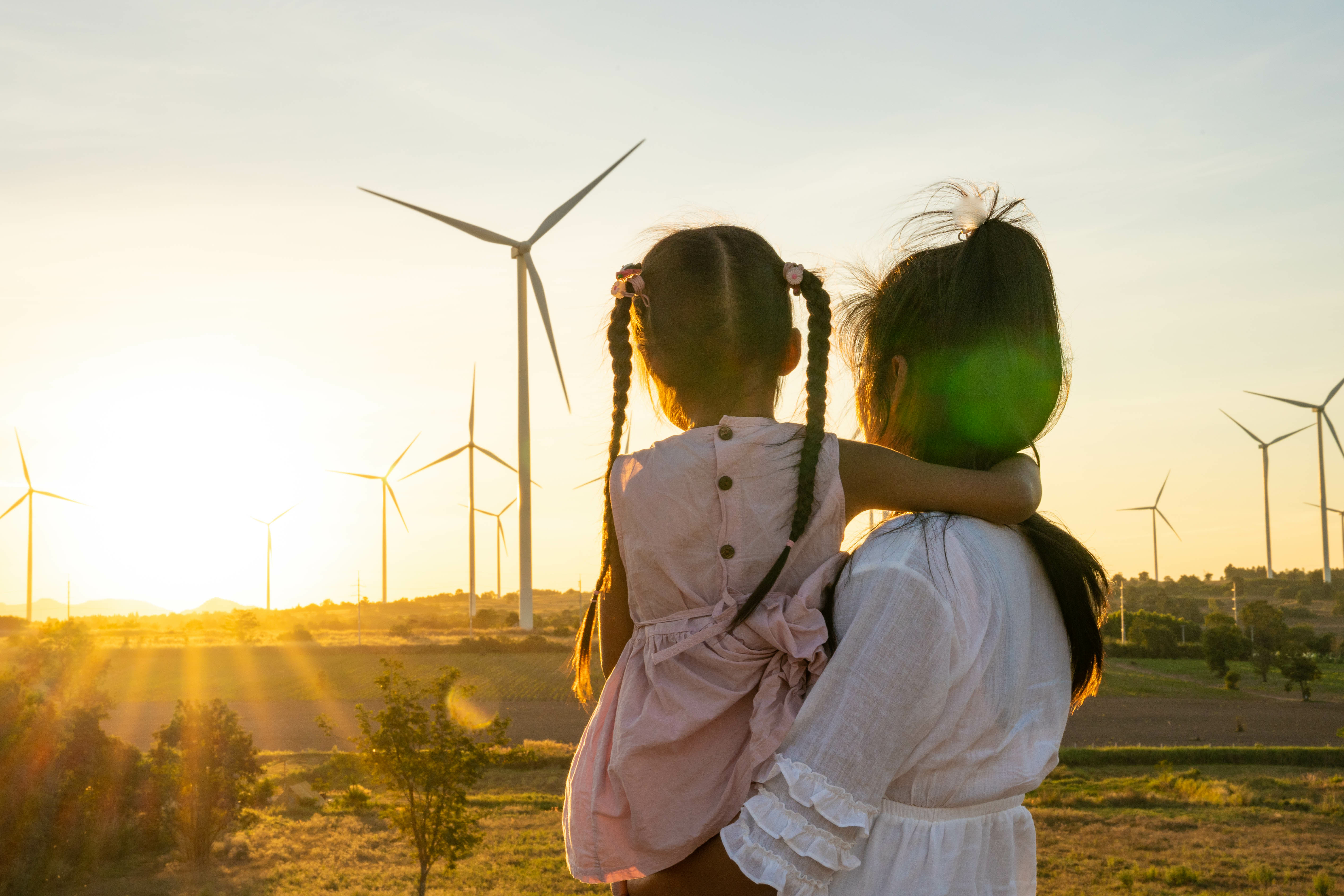 Image - Femme et enfant face à un champ d'éoliennes